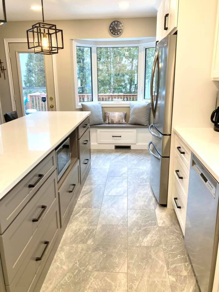 Example of a mid-sized transitional galley ceramic tile and gray floor enclosed kitchen design with a double-bowl sink, shaker cabinets, white cabinets, quartz countertops, gray backsplash, ceramic backsplash, stainless steel appliances, an island and white countertops