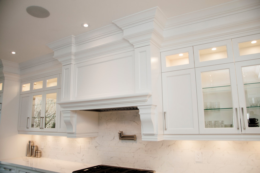 Enclosed kitchen - large transitional l-shaped dark wood floor and brown floor enclosed kitchen idea in Toronto with an undermount sink, shaker cabinets, white cabinets, quartz countertops, white backsplash, marble backsplash, stainless steel appliances, an island and white countertops