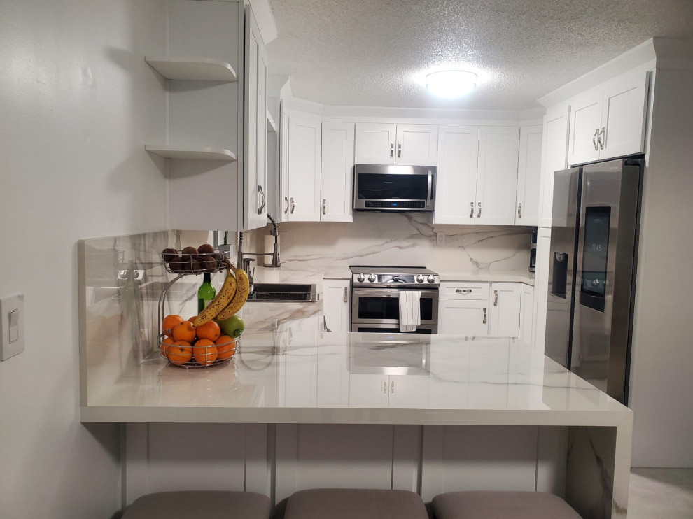 Photo of a medium sized contemporary u-shaped kitchen/diner in Miami with shaker cabinets and white cabinets.