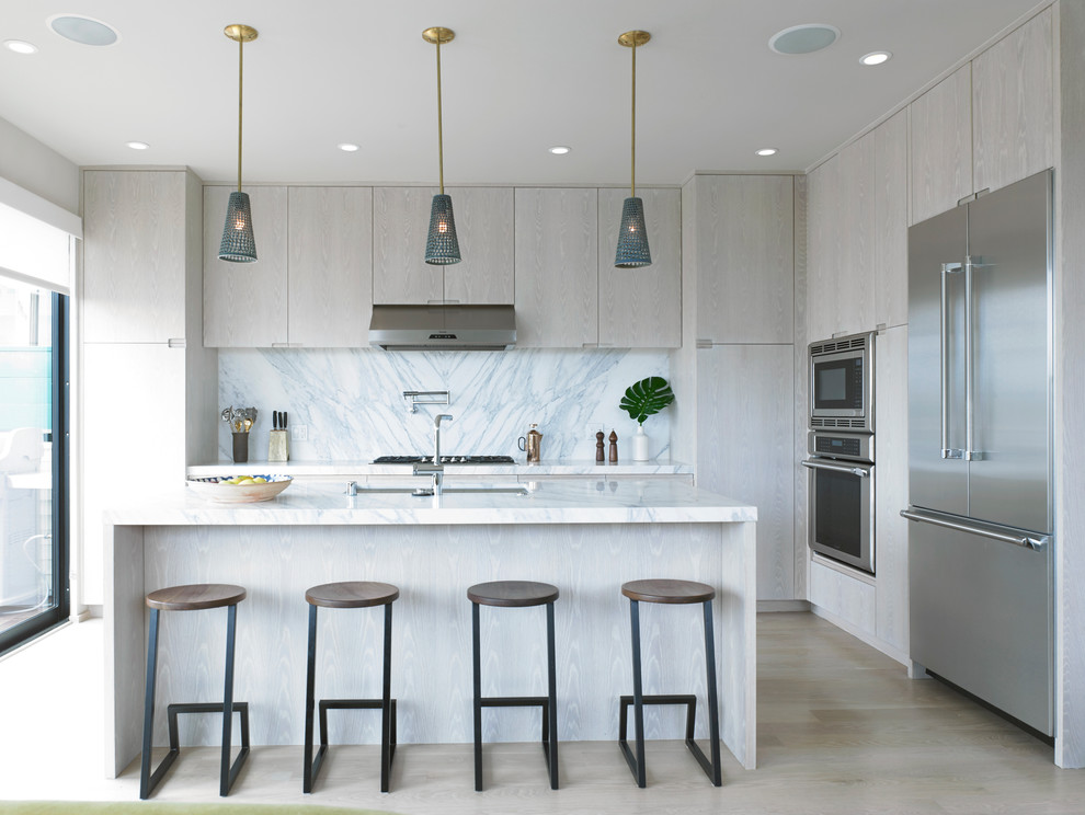 Inspiration for a mid-sized contemporary l-shaped light wood floor and beige floor kitchen remodel in San Francisco with an undermount sink, flat-panel cabinets, light wood cabinets, gray backsplash, stainless steel appliances and an island