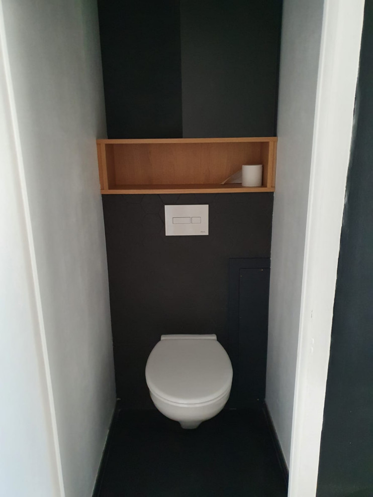 Inspiration for a small traditional cloakroom in Lyon with black cabinets, a wall mounted toilet, black tiles, ceramic flooring, black floors, flat-panel cabinets, ceramic tiles, black walls and a built in vanity unit.