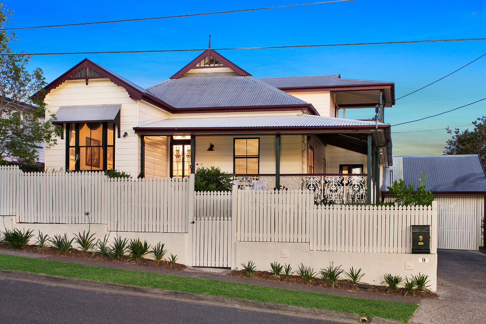 Design ideas for a traditional two-storey beige exterior in Brisbane with wood siding.