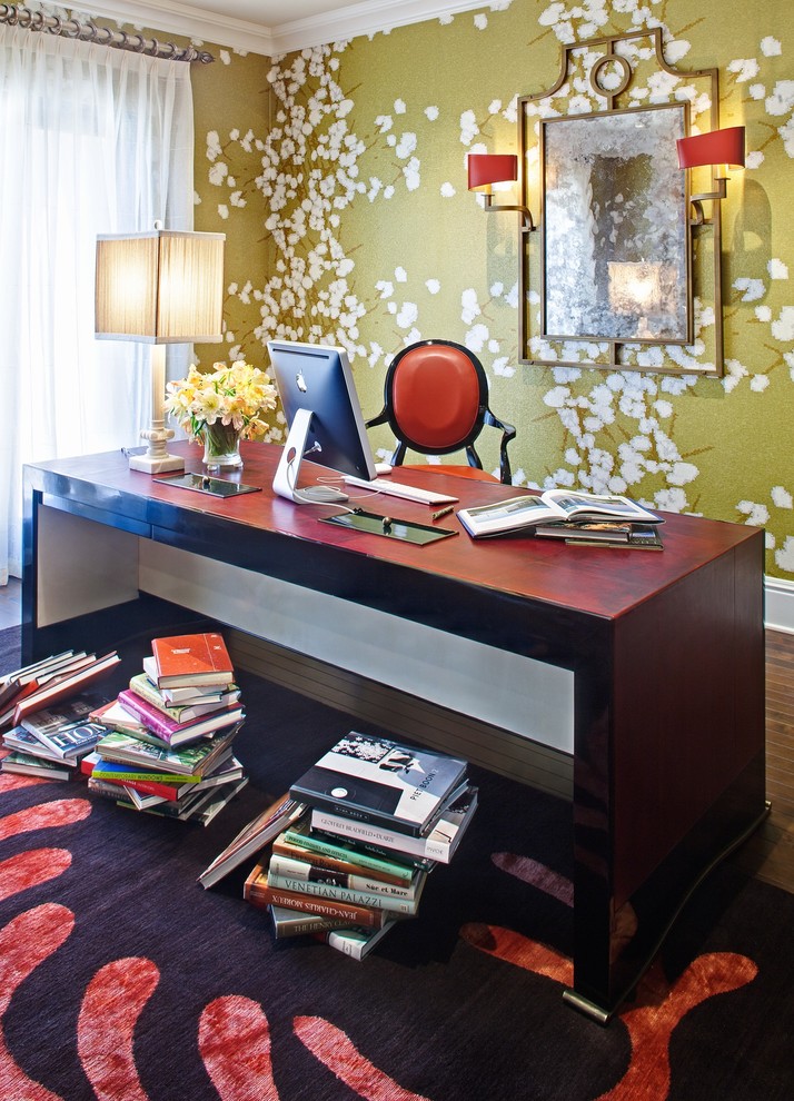 This is an example of a traditional home office in Miami with green walls, dark hardwood floors and a freestanding desk.