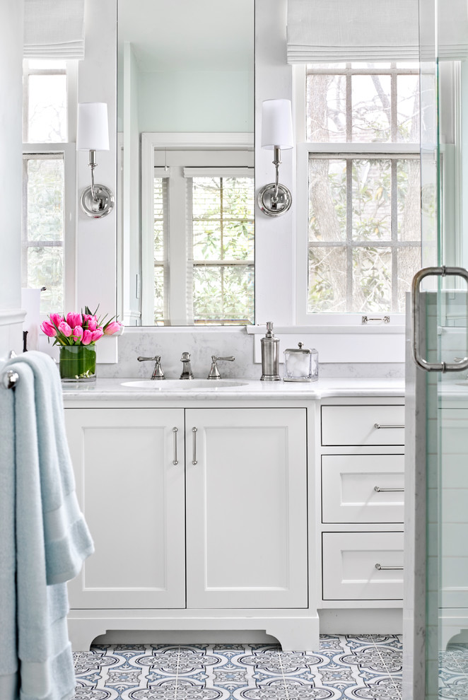 Example of a small classic kids' white tile and ceramic tile marble floor and blue floor corner shower design in Austin with shaker cabinets, white cabinets, a two-piece toilet, blue walls, an undermount sink, quartz countertops, a hinged shower door and white countertops