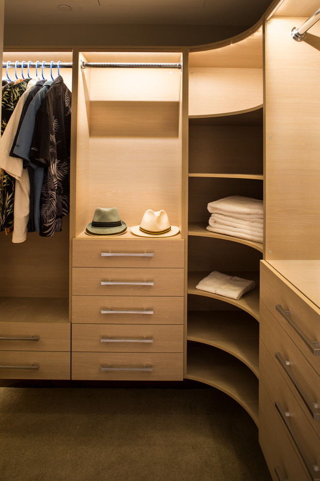 Inspiration for a small contemporary gender-neutral walk-in wardrobe in Hawaii with flat-panel cabinets, light wood cabinets and carpet.