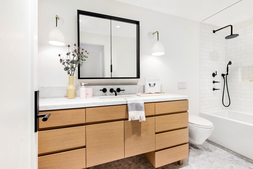 Mid-sized contemporary kids bathroom in San Francisco with flat-panel cabinets, light wood cabinets, a corner tub, a shower/bathtub combo, a wall-mount toilet, white tile, marble, white walls, mosaic tile floors, an undermount sink, marble benchtops, white floor, a shower curtain, white benchtops, a single vanity and a freestanding vanity.