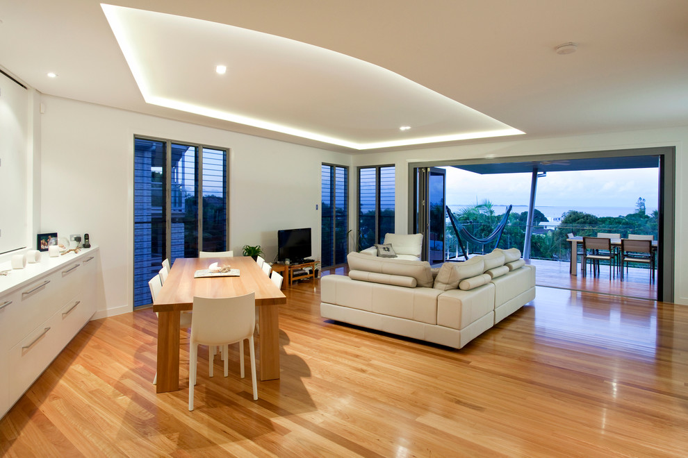 Inspiration for a large contemporary open concept living room in Brisbane with white walls, no fireplace, a freestanding tv, light hardwood floors and brown floor.