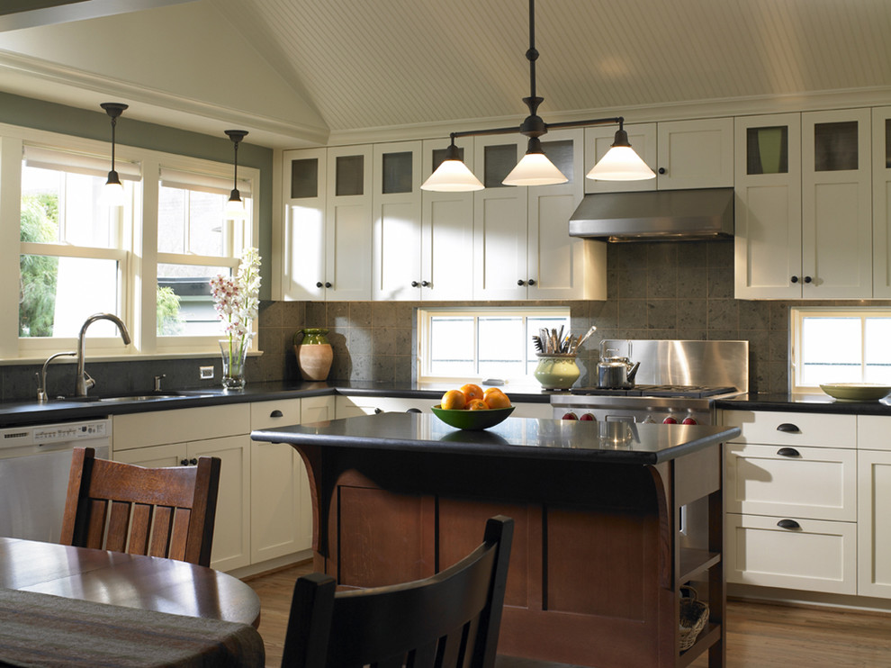 Photo of a traditional eat-in kitchen in Seattle with stainless steel appliances, granite benchtops, shaker cabinets, white cabinets, grey splashback and limestone splashback.