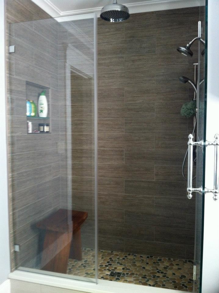 Photo of a small contemporary master bathroom in Nashville with flat-panel cabinets, dark wood cabinets, an alcove shower, a one-piece toilet, multi-coloured tile, pebble tile, porcelain floors, a drop-in sink and engineered quartz benchtops.