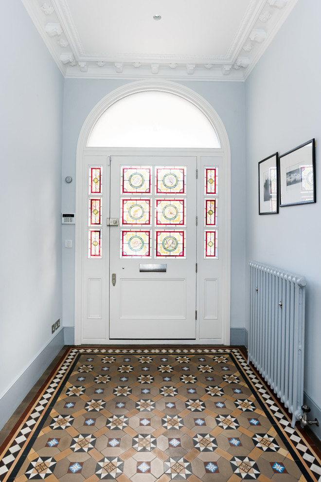 Inspiration for a large traditional entry hall in London with blue walls, a single front door, a white front door and brown floor.