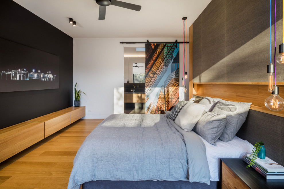 Design ideas for a large contemporary master bedroom in Melbourne with grey walls, brown floor and medium hardwood floors.