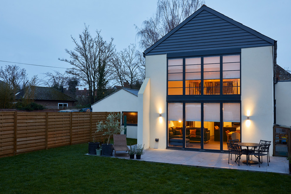 This is an example of a contemporary two-storey white house exterior in London with metal siding and a gable roof.