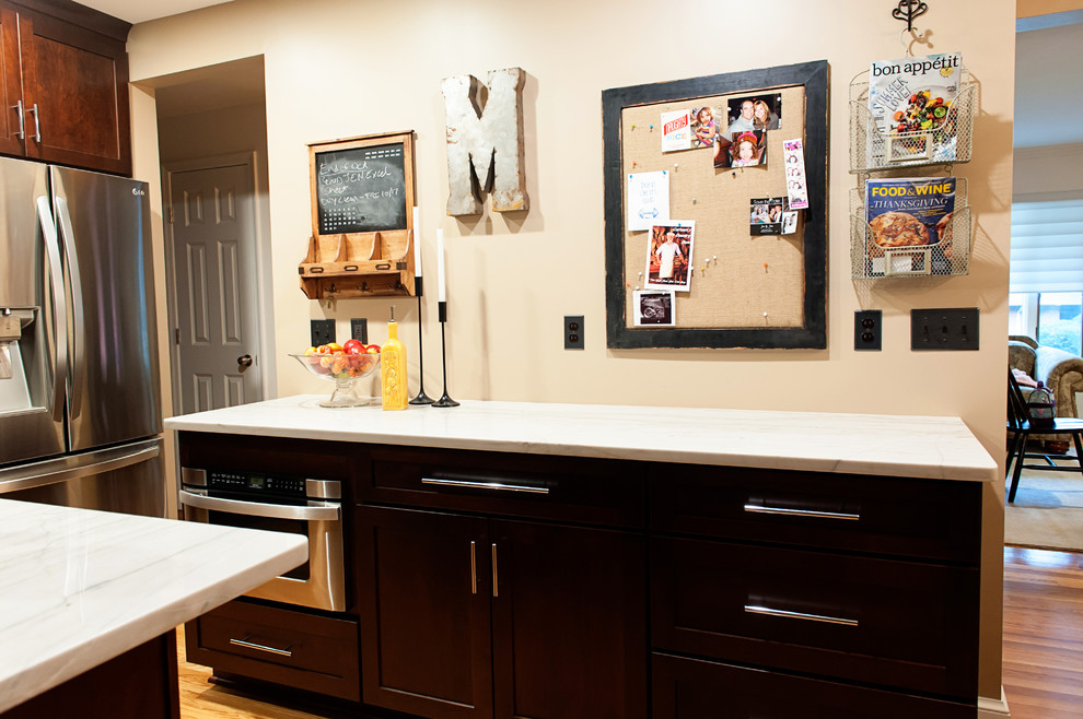 Inspiration for a mid-sized transitional galley light wood floor eat-in kitchen remodel in DC Metro with a farmhouse sink, shaker cabinets, dark wood cabinets, quartzite countertops, metallic backsplash, porcelain backsplash, stainless steel appliances and an island