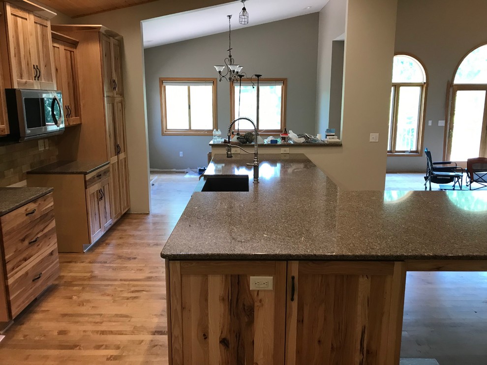 Example of a mid-sized mountain style galley eat-in kitchen design with an island