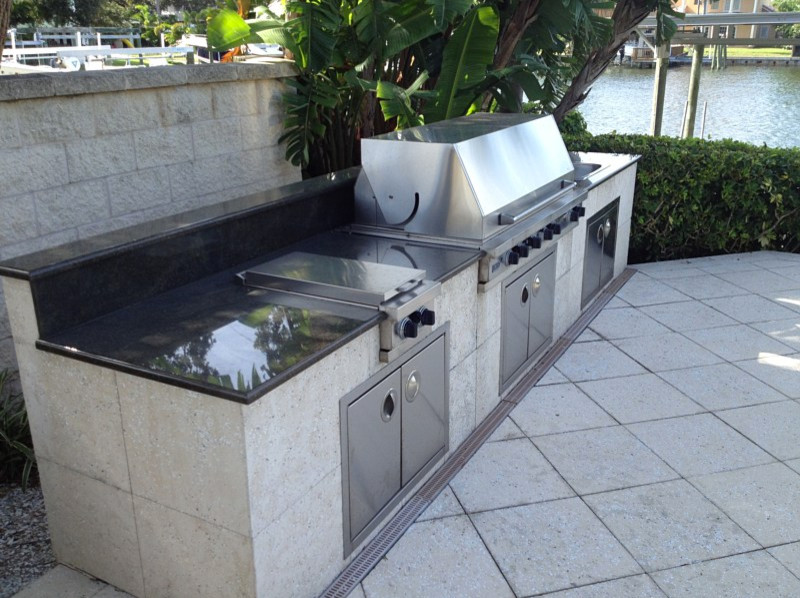 Photo of a large traditional backyard patio in Tampa with an outdoor kitchen, tile and no cover.