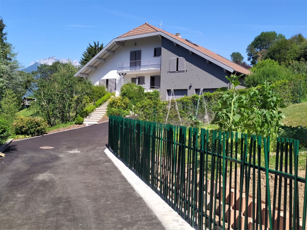 Inspiration pour une grande façade de maison minimaliste à un étage avec un revêtement mixte, un toit à deux pans et un toit en tuile.