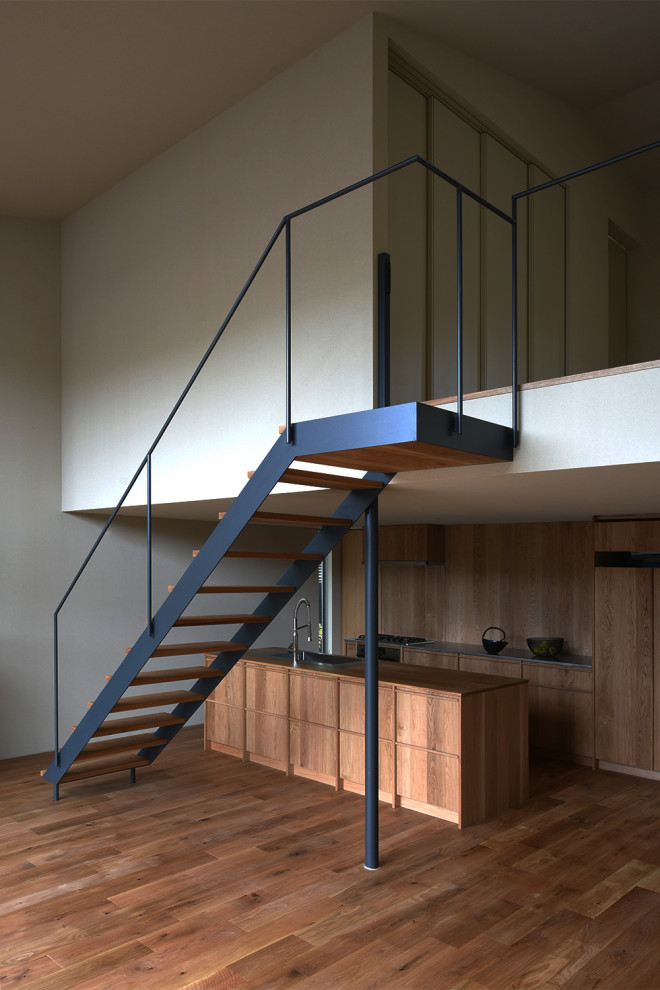 Свежая идея для дизайна: большая лестница в стиле модернизм с деревянными ступенями и металлическими перилами - отличное фото интерьера