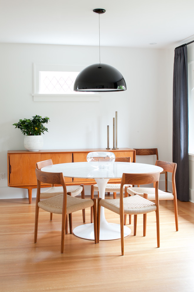 Design ideas for a midcentury dining room in Vancouver with medium hardwood floors.