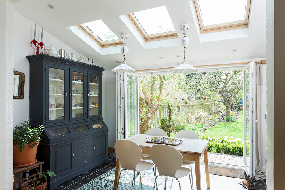 Mid-sized traditional separate dining room in London with white walls, ceramic floors and black floor.