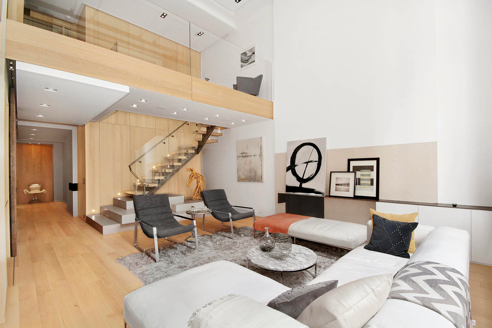 Photo of a large scandinavian open concept living room in New York with light hardwood floors and white walls.