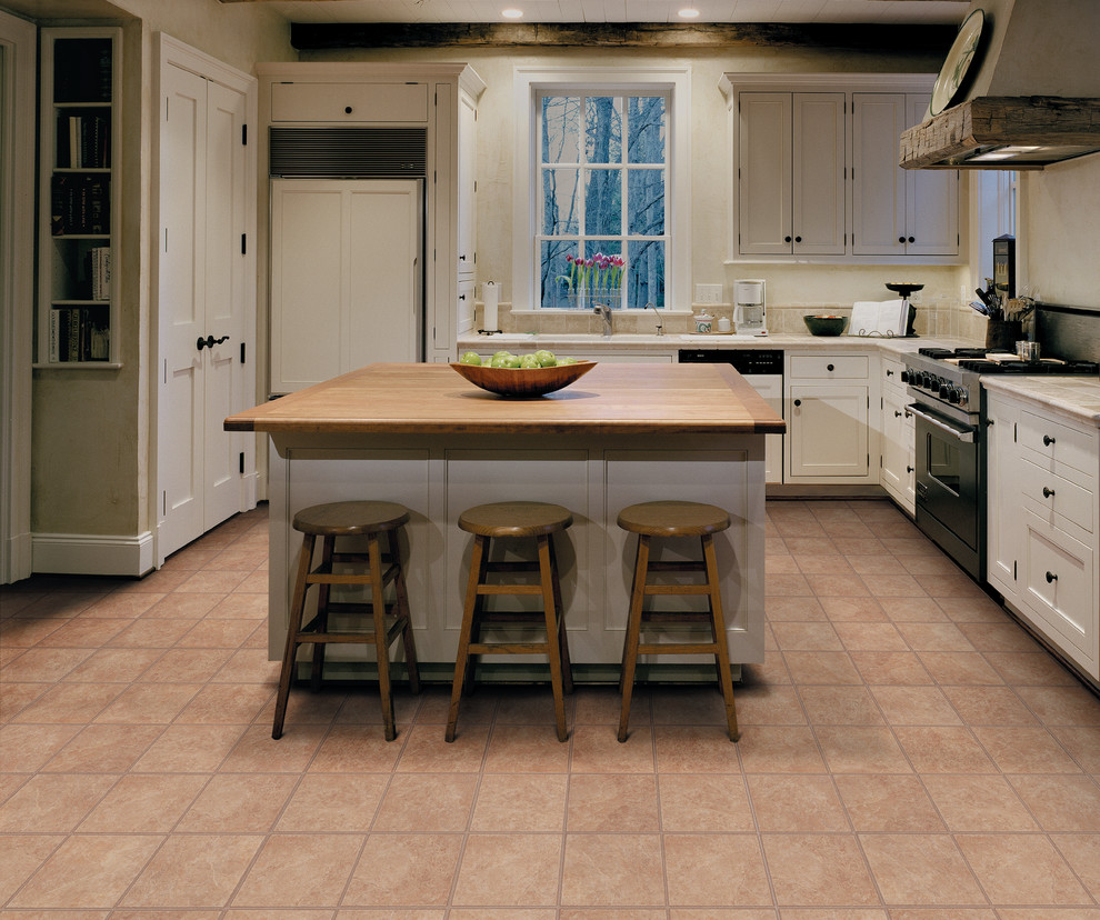 Kitchen - transitional l-shaped kitchen idea in Miami with white cabinets, paneled appliances and an island