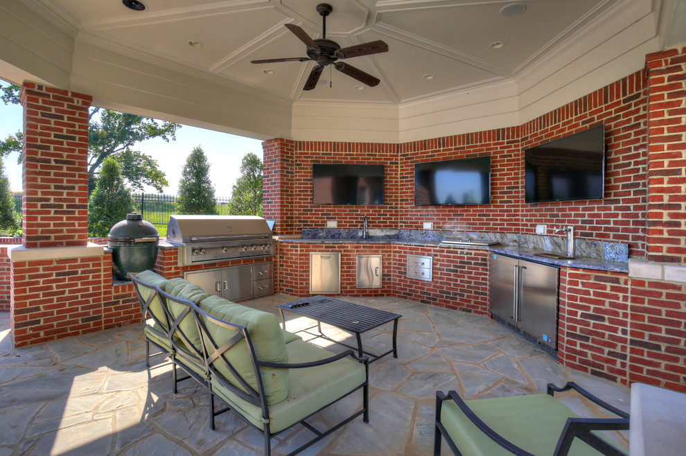 Photo of a large traditional backyard patio in Louisville with an outdoor kitchen, natural stone pavers and a gazebo/cabana.