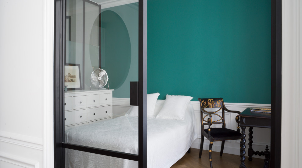 This is an example of a large transitional bedroom in Paris with green walls, light hardwood floors and brown floor.