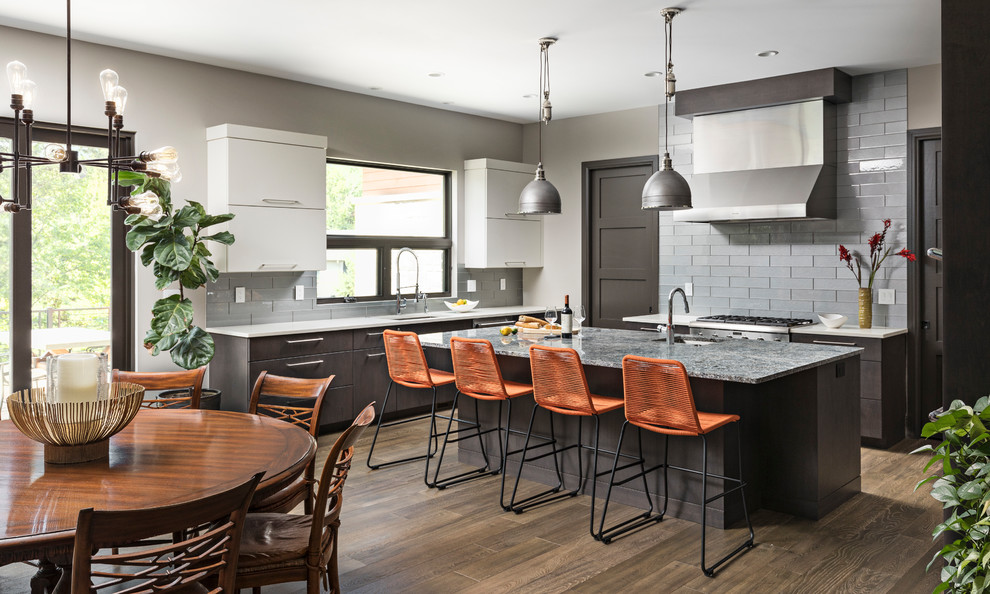 Eat-in kitchen - large transitional l-shaped medium tone wood floor and brown floor eat-in kitchen idea in Detroit with flat-panel cabinets, dark wood cabinets, quartz countertops, gray backsplash, subway tile backsplash, stainless steel appliances, an island, gray countertops and an undermount sink