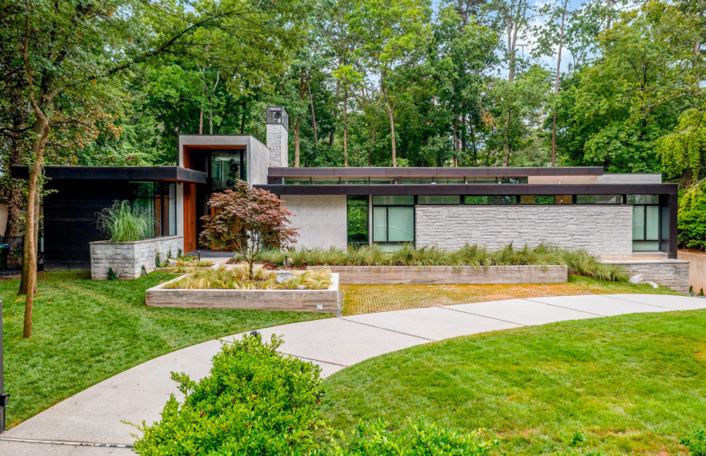 Inspiration for a large modern one-story stone exterior home remodel in Atlanta with a black roof