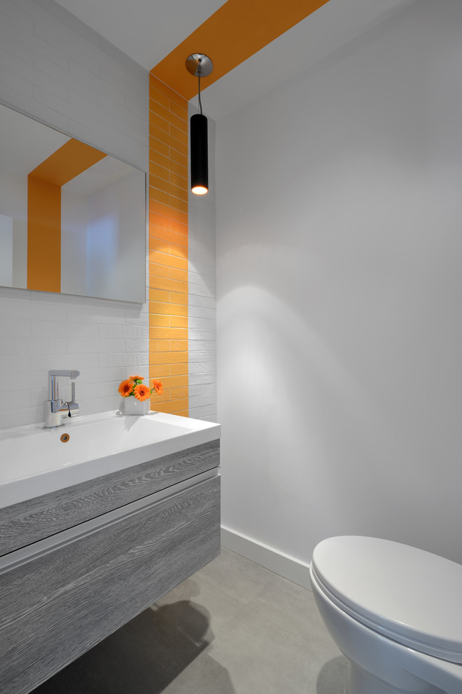 Design ideas for a mid-sized contemporary bathroom in Toronto with white tile, white walls, concrete floors, an integrated sink and grey floor.