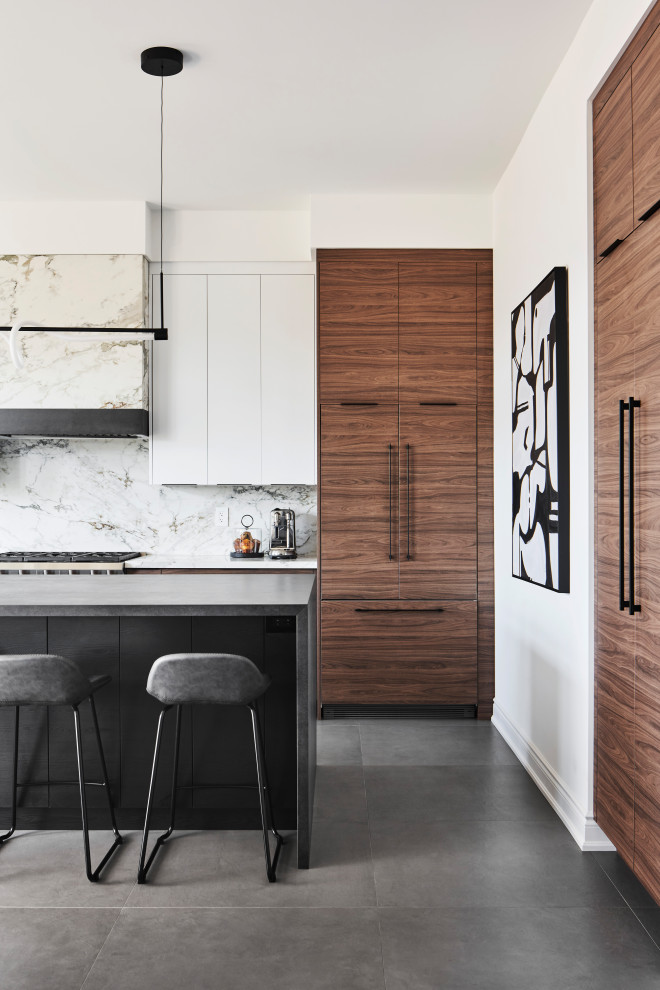 Photo of a large modern l-shaped open plan kitchen in Toronto with a double-bowl sink, flat-panel cabinets, medium wood cabinets, tile benchtops, white splashback, porcelain splashback, stainless steel appliances, porcelain floors, with island, grey floor and black benchtop.