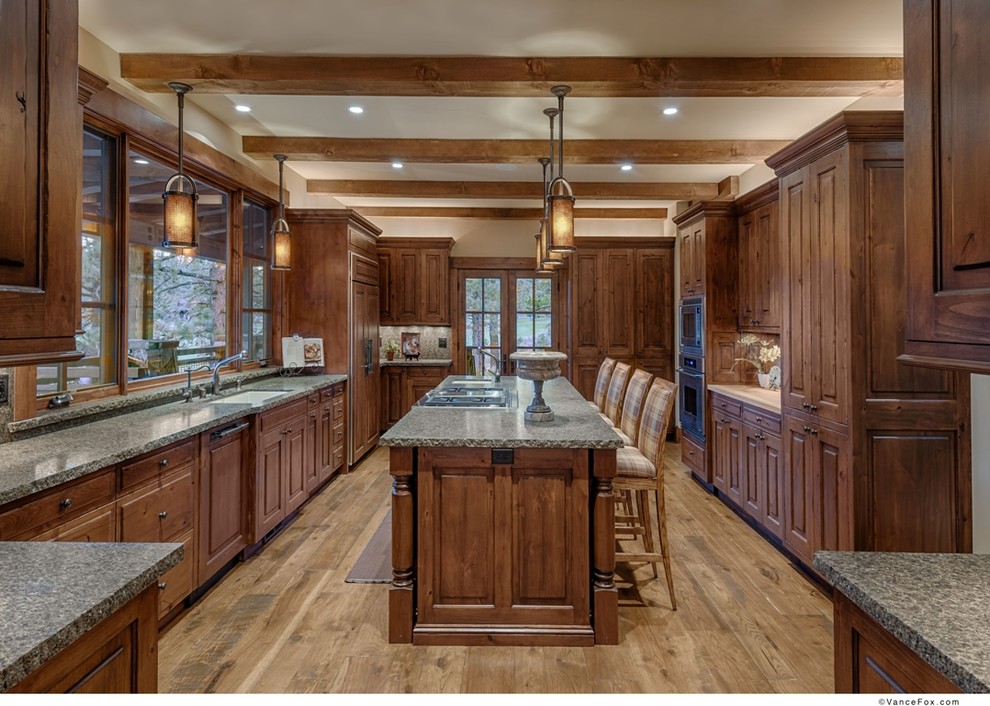 Photo of a large arts and crafts galley separate kitchen in Sacramento with an undermount sink, medium wood cabinets, granite benchtops, green splashback, stone slab splashback, stainless steel appliances, light hardwood floors, with island and green benchtop.
