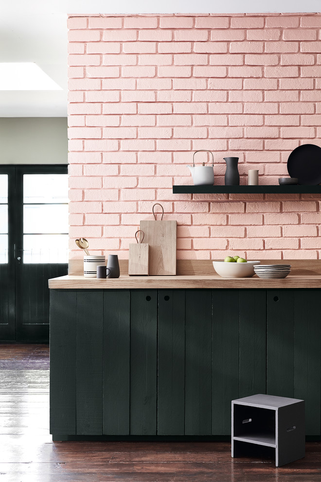 Inspiration for an eclectic kitchen in Moscow with flat-panel cabinets, black cabinets, wood benchtops, pink splashback, brick splashback, dark hardwood floors and brown floor.