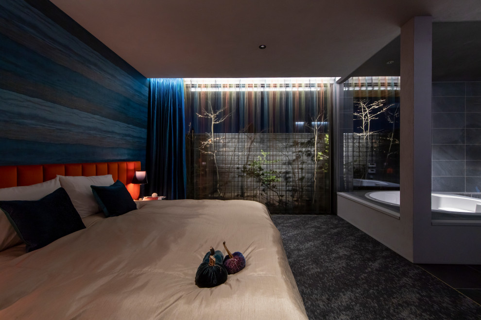 Großes Modernes Hauptschlafzimmer mit blauer Wandfarbe, Teppichboden, schwarzem Boden, Holzdielendecke und Tapetenwänden in Sonstige