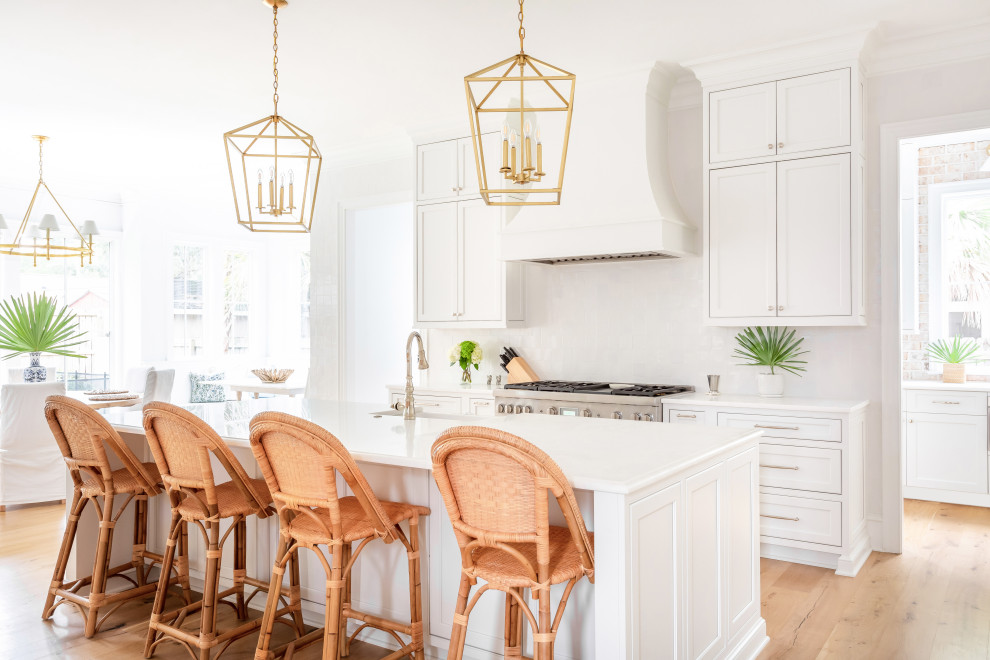 Beach style light wood floor kitchen photo in Charleston with a farmhouse sink, shaker cabinets, white cabinets, marble countertops, ceramic backsplash and an island