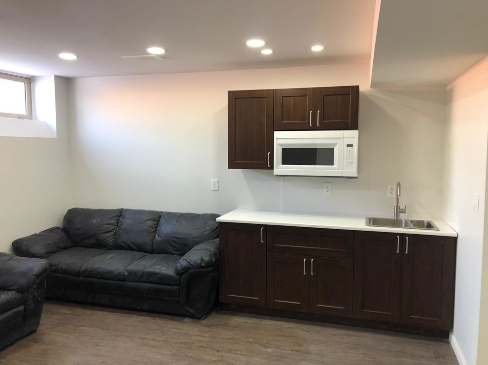 Basement - mid-sized modern underground vinyl floor and gray floor basement idea with beige walls