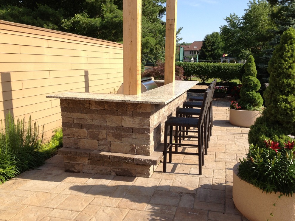 Design ideas for a mid-sized traditional backyard patio in Columbus with concrete pavers.
