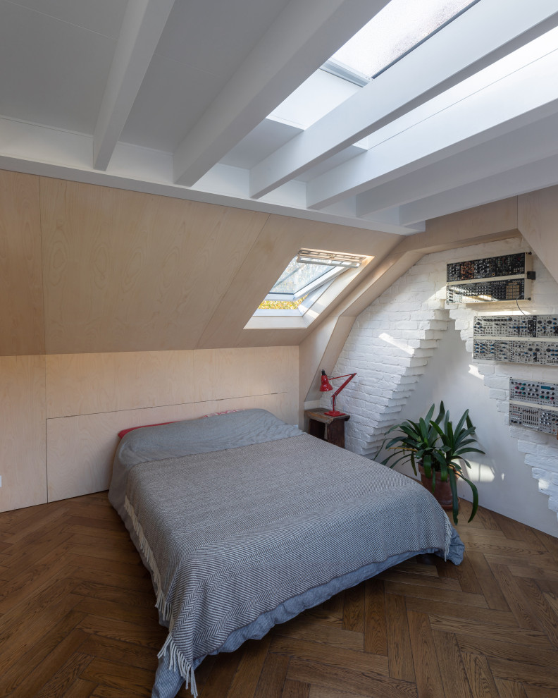 Cette image montre une chambre d'amis bohème en bois de taille moyenne avec un sol en bois brun et poutres apparentes.