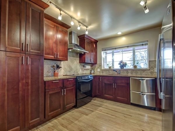 Enclosed kitchen - mid-sized transitional u-shaped light wood floor enclosed kitchen idea in Denver with an undermount sink, recessed-panel cabinets, medium tone wood cabinets, quartz countertops, gray backsplash, ceramic backsplash, stainless steel appliances and no island