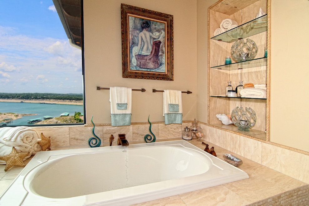This is an example of a large mediterranean master bathroom in Austin with a drop-in sink, furniture-like cabinets, white cabinets, granite benchtops, a drop-in tub, a double shower, beige tile, stone tile, white walls and travertine floors.