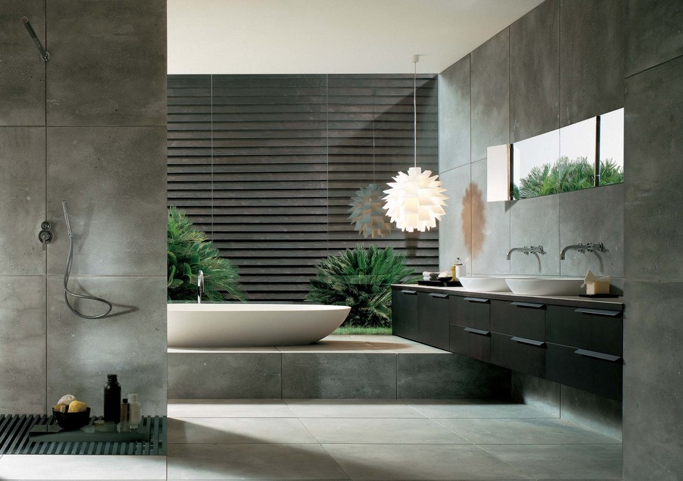 Cette photo montre une salle de bain tendance en bois foncé avec une vasque, un placard à porte plane, une baignoire indépendante, une douche ouverte et un carrelage gris.