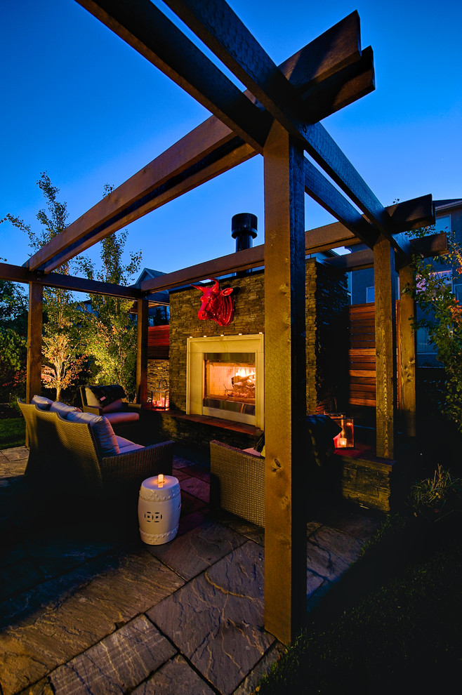 This is an example of a small transitional backyard patio in Calgary with a fire feature.
