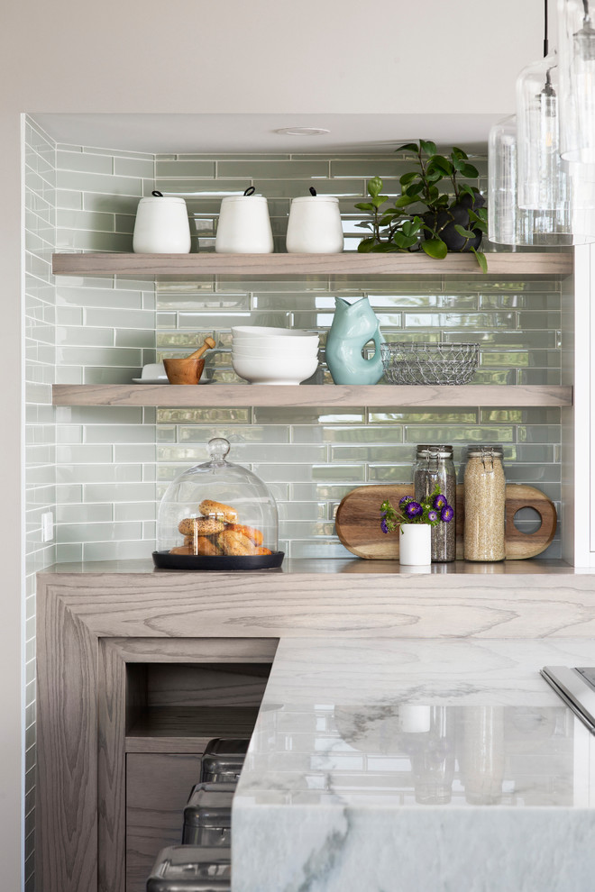 Photo of a mid-sized transitional l-shaped eat-in kitchen in Calgary with an undermount sink, raised-panel cabinets, white cabinets, grey splashback, glass tile splashback, stainless steel appliances, dark hardwood floors, a peninsula, brown floor and grey benchtop.