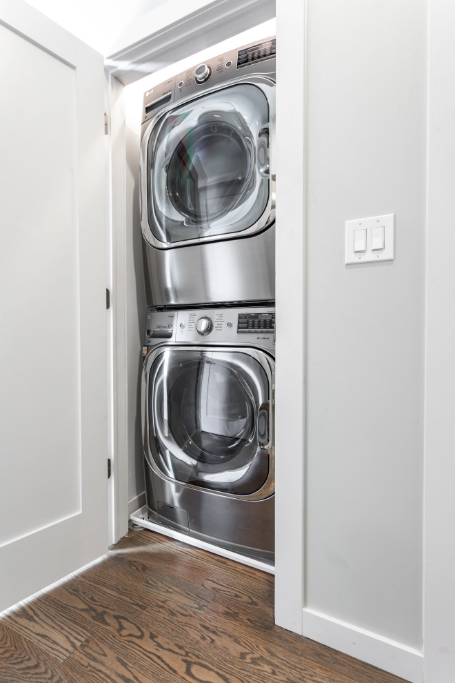 Photo of a mid-sized contemporary laundry room in Chicago with flat-panel cabinets, brown cabinets, white walls and brown floor.
