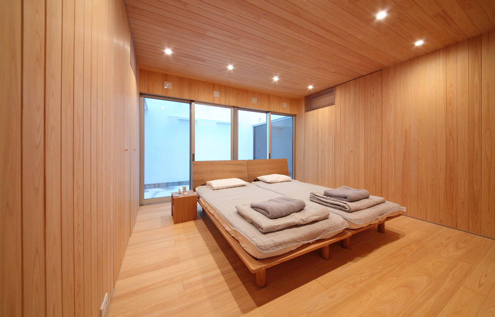 Mid-sized contemporary bedroom in Osaka with brown walls, medium hardwood floors and brown floor.