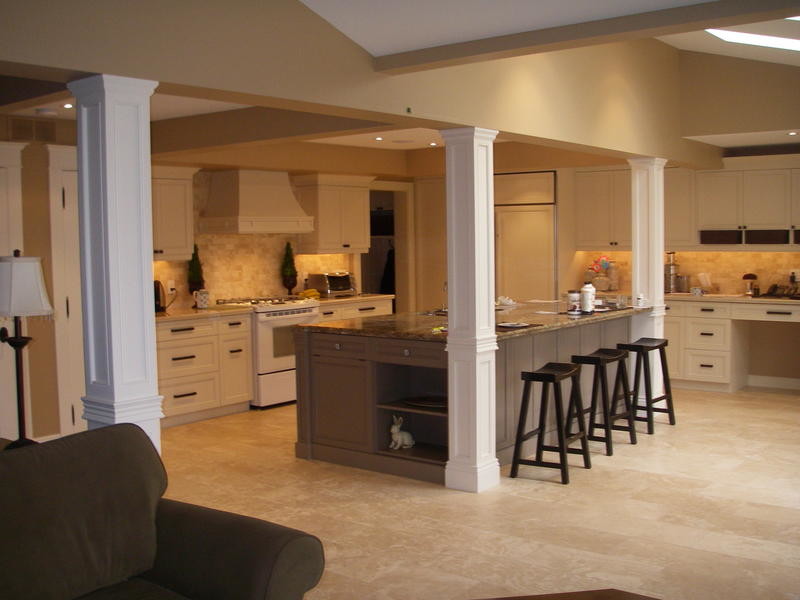 Mid-sized elegant l-shaped terra-cotta tile home design photo with recessed-panel cabinets, white cabinets, granite countertops, multicolored backsplash, stone tile backsplash, white appliances and an island