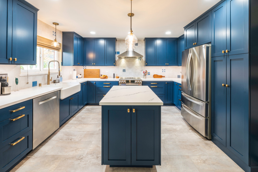 Inspiration for a large transitional u-shaped eat-in kitchen in San Luis Obispo with a farmhouse sink, shaker cabinets, blue cabinets, quartz benchtops, white splashback, ceramic splashback, stainless steel appliances, with island and white benchtop.