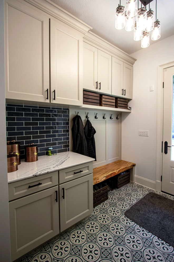 Mid-sized transitional galley utility room in Cleveland with flat-panel cabinets, white cabinets, blue splashback, engineered quartz splashback, white walls, ceramic floors, a stacked washer and dryer, blue floor and white benchtop.