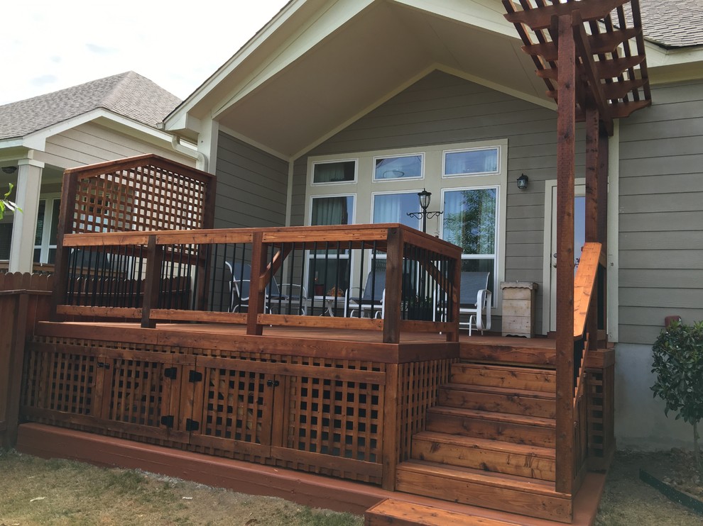 Photo of a small traditional backyard deck in Other with a pergola.