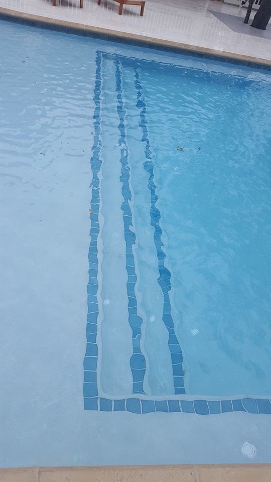 Example of a mid-sized transitional backyard concrete paver and rectangular infinity pool fountain design in Miami